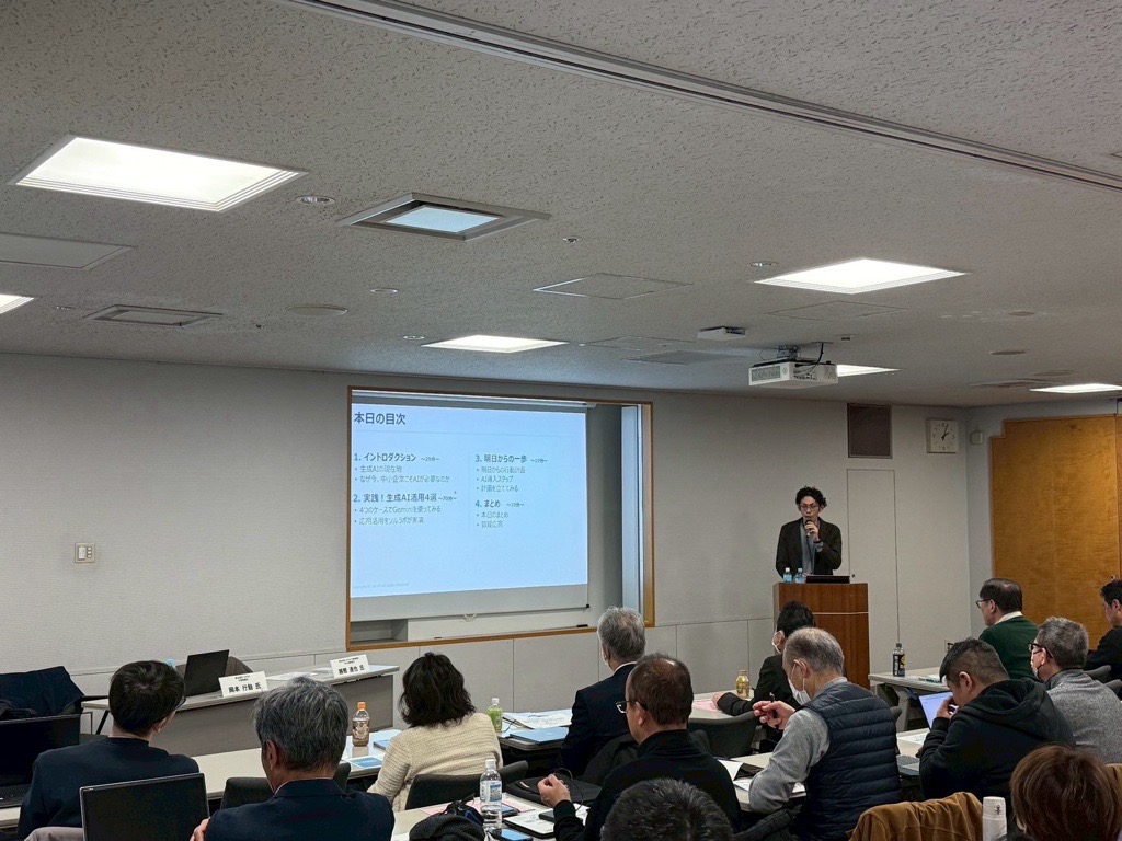 大阪産業創造館の生成AIセミナーで登壇するソルラボ代表。本日の目次スライドを背景に講演中
